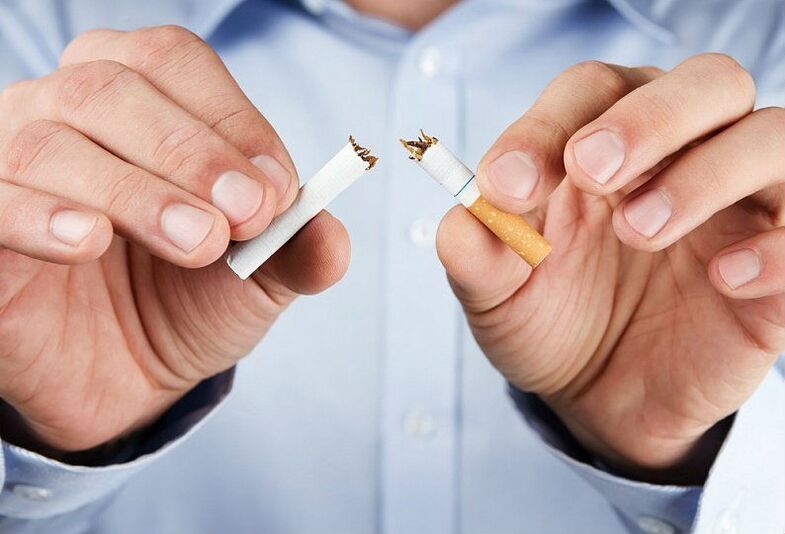 Um homem quebra um cigarro